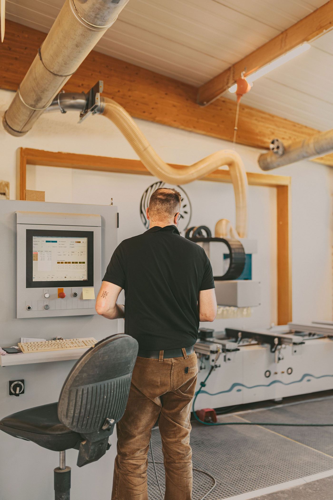 Tischler bedient die CNC-Anlage für Sanierungs- und Modernisierungsprojekte